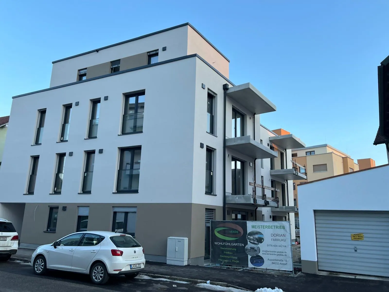 Fertiggestelltes Mehrfamilienhaus mit heller Fassade, Mehrgewerke-Ausführung durch BIHZ
